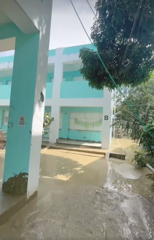 The Makarios school exterior with mud waterline visible on the walls.