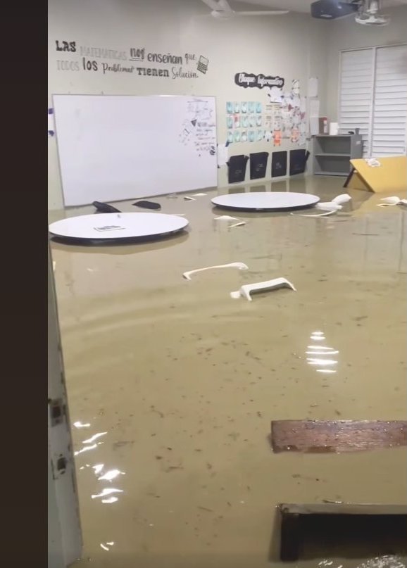 The Makarios math classroom flooded, with a sign on the wall reading 'Las matemáticas nos enseñan que todos los problemas tienen solución.'